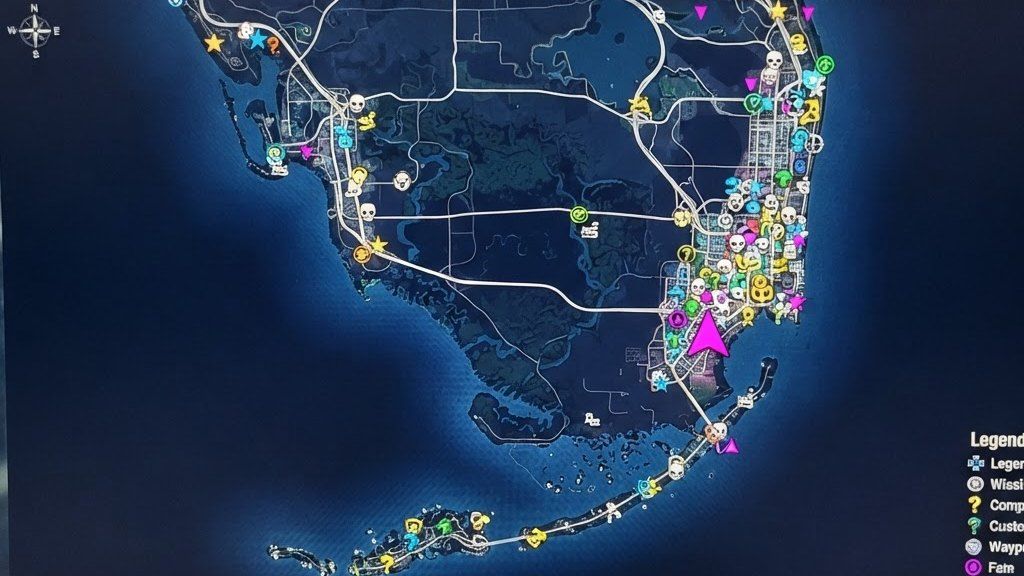 Blurred photo of a monitor showing a dark game map with colorful icons