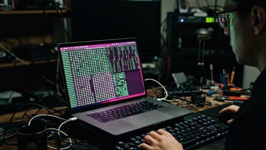 A laptop displaying a hex dump in a dim room